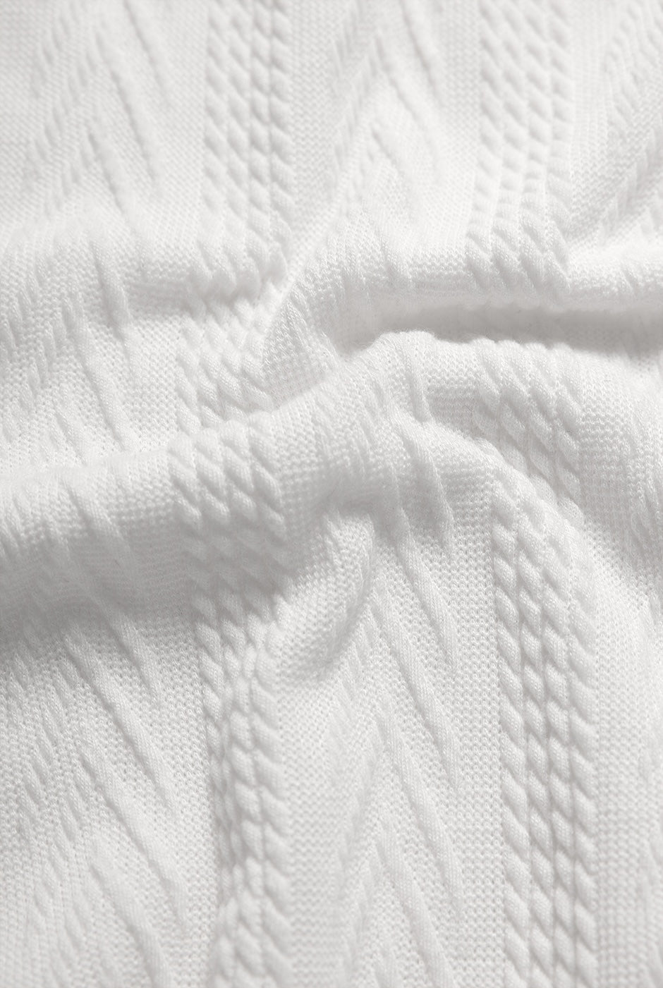 Blusa recta blanca tejida, manga corta y cuello redondo.