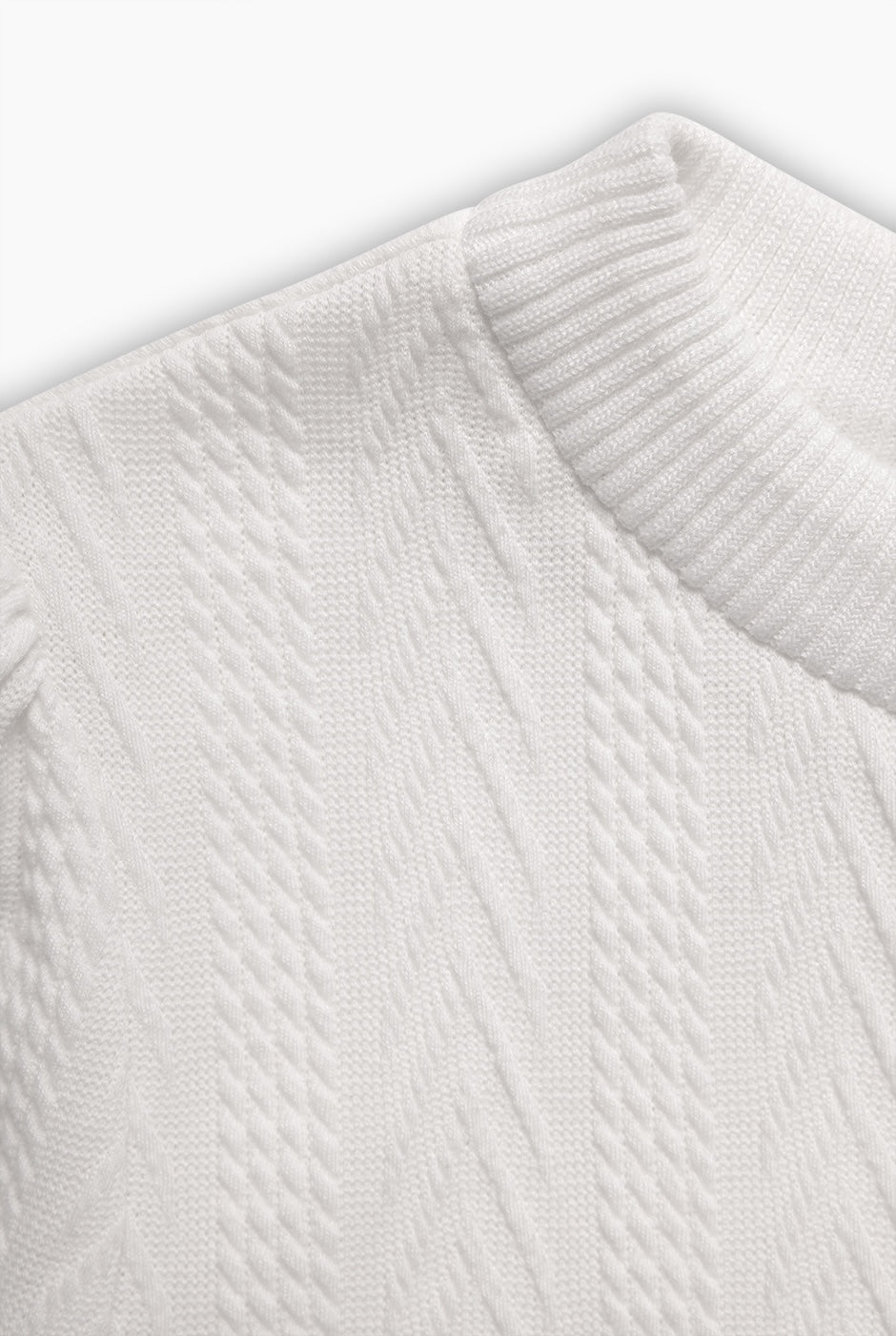 Blusa recta blanca tejida, manga corta y cuello redondo.
