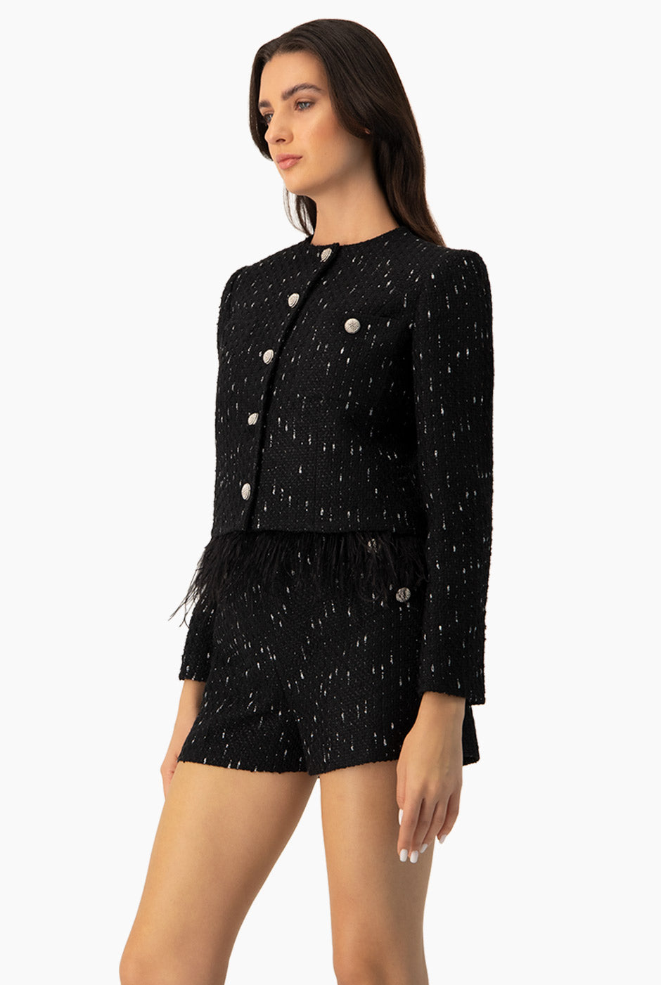 Saco corto negro con botones y plumas en el bajo