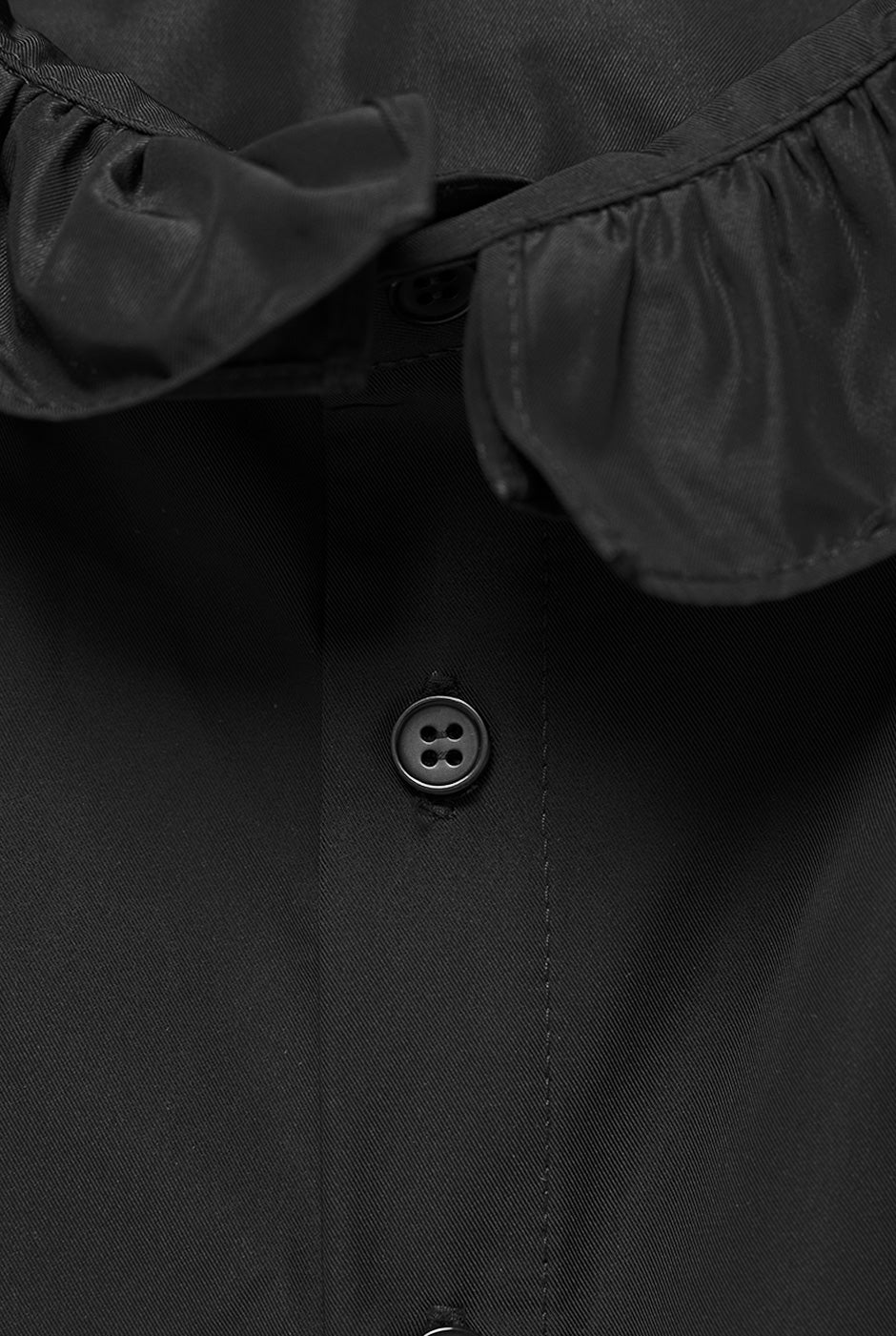 Blusa negra de cuello alto con botones frontales